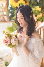 woman in white floral wedding dress holding bouquet of flowers