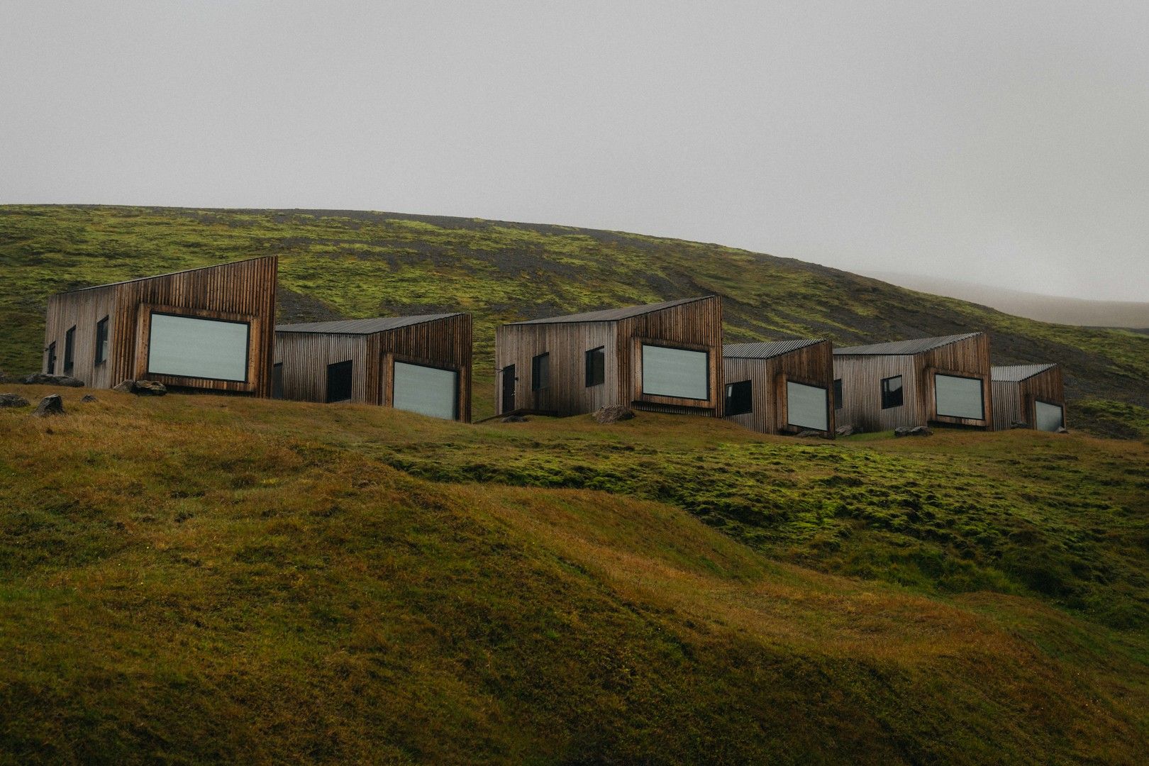 A group of buildings sitting on top of a lush green hillside